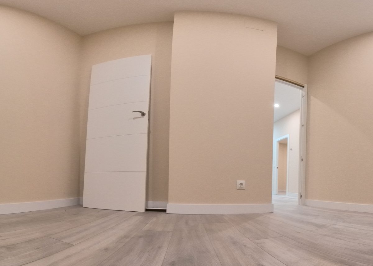 Estancia de una vivienda terminada en un antiguo local de Burgos capital, con suelo laminado y puerta blanca